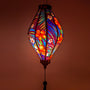 Glowing Tube shaped lantern with tropical flowers and palm leaves.