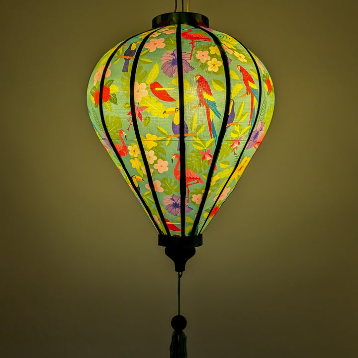 Glowing lantern with colourful birds and floral pattern on a blue teal background