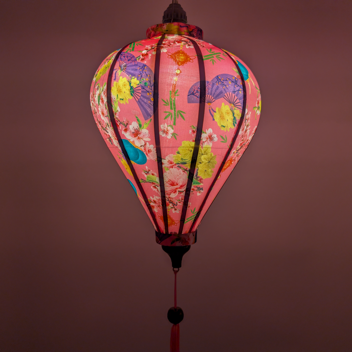 Balloon shaped lantern with floral patterns glowing and creating a pink background
