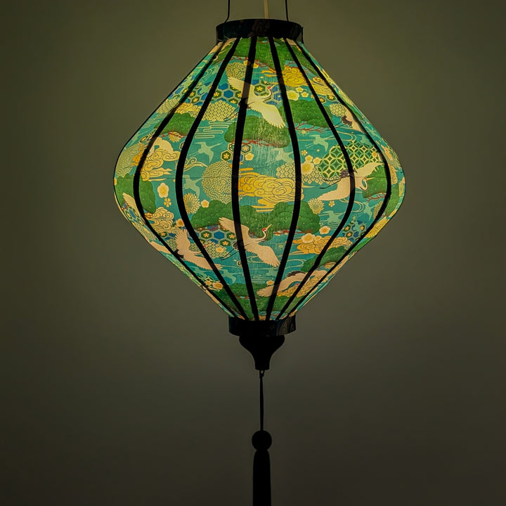 Glowing lantern with green and yellow patterns on a teal featuring cranes and geometric patterns