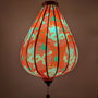Glowing Vietnamese silk lantern with dragon design on bold red background.