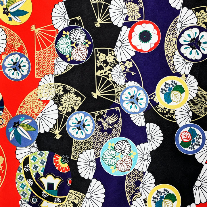Polyester silk fabric with abstract print in red, black, blue and gold outline.