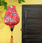 Lantern with Blacknaped Oriole birds perched in a tree with pink flowers .