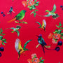 Polyester silk fabric used to create Vietnamese lanterns featuring a print of various birds in flight with bunches of peach flowers against a hot pink backdrop.