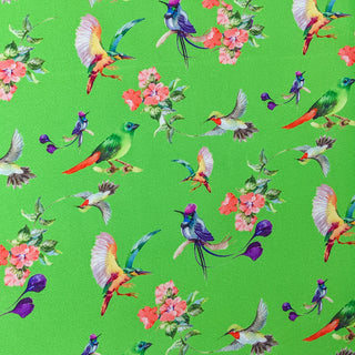 Polyester silk fabric with delicate peach flowers enhanced by various feathery avian species on an emerald green backdrop.
