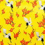 Polyester silk fabric with a print of cranes surrounded by orange flowers on a bright yellow background.