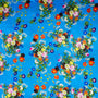 Blue polyester silk fabric with a print of wild flowers in a rainbow of colours.