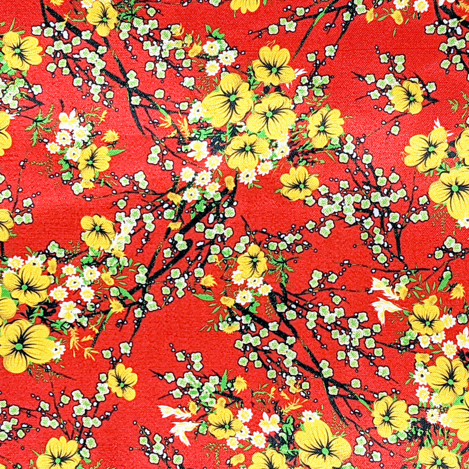 Red polyester silk fabric with a print of yellow flower blossoms with hints of green and white.