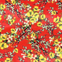 Red polyester silk fabric with a print of yellow flower blossoms with hints of green and white.