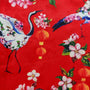 Polyester silk fabric with large Asian red-necked birds and round lanterns, surrounded by pink and white flowers on a red background.