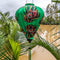 Balloon shaped lantern with flaming flowers in bloom on a vibrant green.