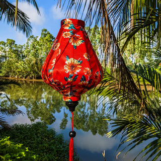 The lantern has a teardrop-like shape, a black wooden tail, and a red tassel hanging from the bottom, enhancing its traditional charm.