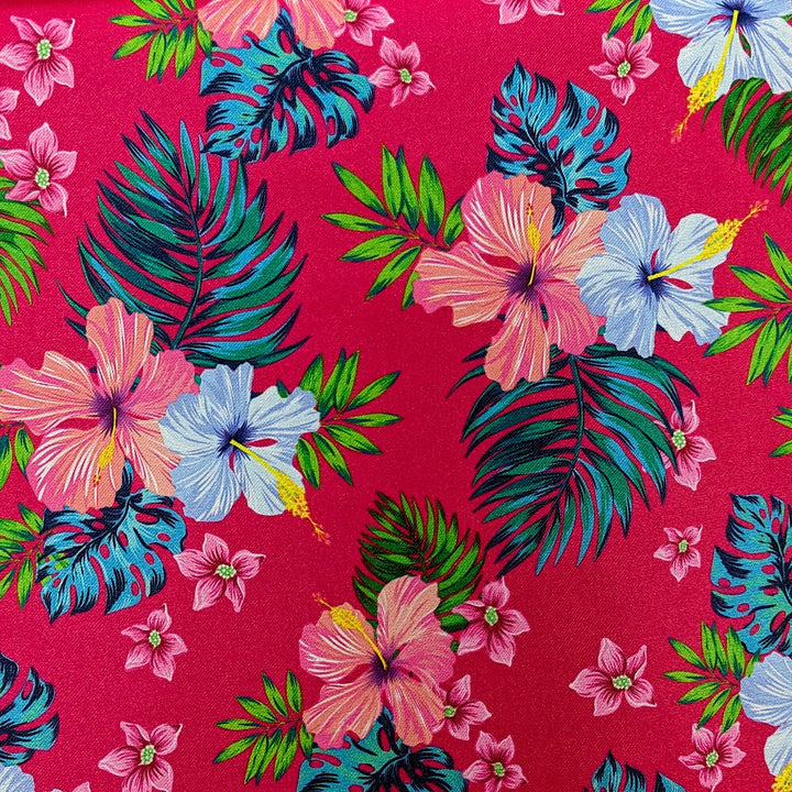 Polyester silk fabric with hibiscus flowers in shades of blue and pink. The flowers are set against a bright hot pink, with green and teal leaves.