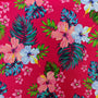 Polyester silk fabric with hibiscus flowers in shades of blue and pink. The flowers are set against a bright hot pink, with green and teal leaves.