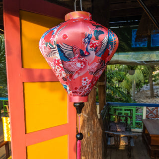 Diamond shape lantern with large phoenix bird rising with blue, gold, and pink wings.