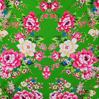 Polyester silk fabric with pink and yellow roses on green background.