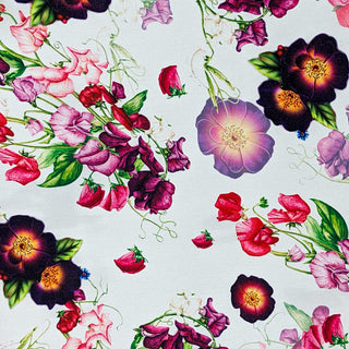 Polyester silk fabric with botanical floral pattern with pinks and purples on white background. 