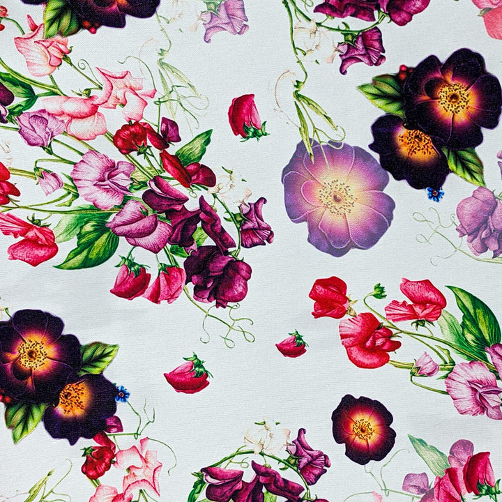 Polyester silk fabric with botanical floral pattern with pinks and purples on white background. 
