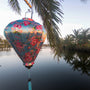 Balloon shaped lantern in the wild featuring pink and yellow roses on a light blue background.