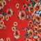 Polyester silk with bold red fabric adorned with vibrant sunflower patterns. 