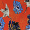 Polyester silk fabric with white red-headed cranes, surrounded by gold and blue flowers on a red background. 